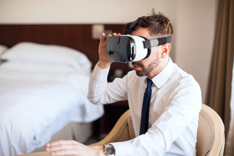 A person using a VR headset in a hotel room- example of AR and VR in hospitality