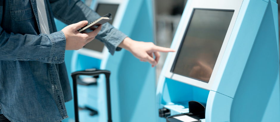 AI in hospitality- a person using an AI-enabled kiosk for check-in