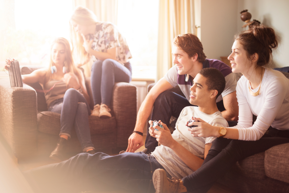 a student housing common room with students using connected technology for gaming, viewing content, and more