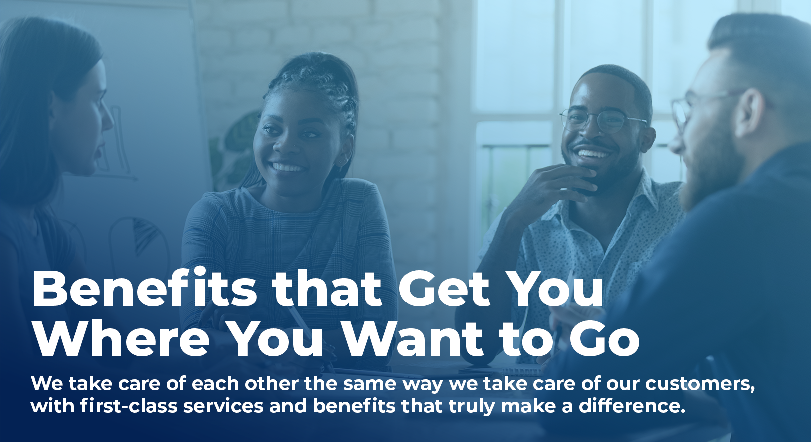 group of people around a table, smiling, talking, and taking notes, overlaid with text that says "Benefits that Get You Where You Want to Go- We take care of each other the same way we take care of our customers, with first-class services and benefits that truly make a difference."