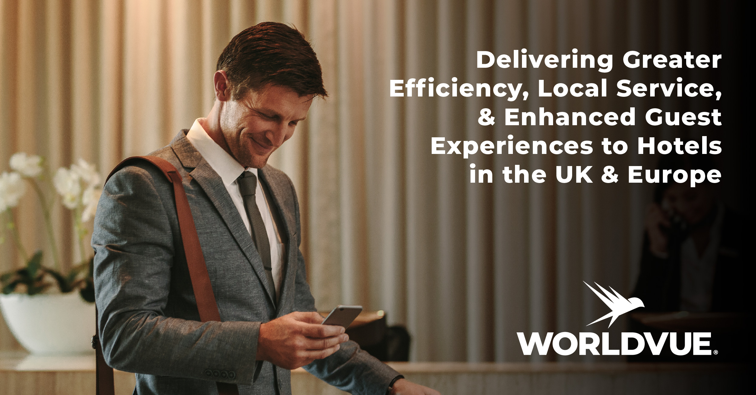 image of happy guest using WiFi in a hotel lobby, with WorldVue logo and text saying "Delivering Greater Efficiency, Local Service, and Enhanced Guest Experiences to Hotels in the UK and Europe"